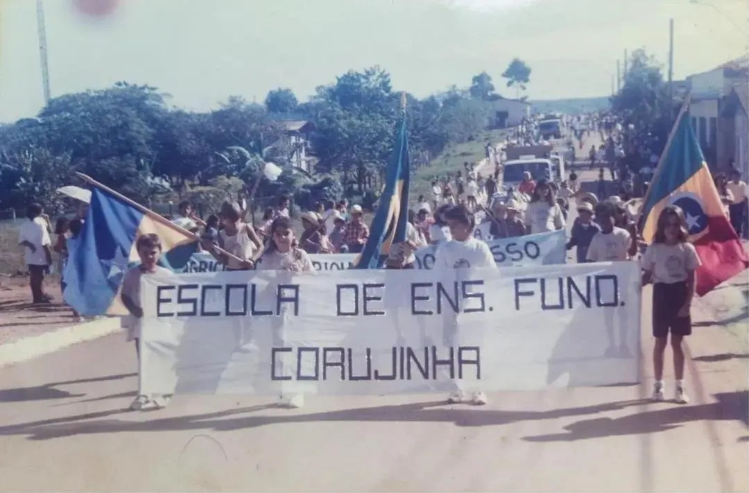 Foto antiga: desfile com a faixa 'Escola de Ens. Fund. Corujinha'